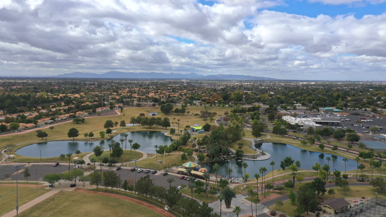 An aerial view capturing Freestone District Park in Gilbert, Arizona. The image showcases the park's layout and amenities, including walking paths, sports fields, and recreational areas. 