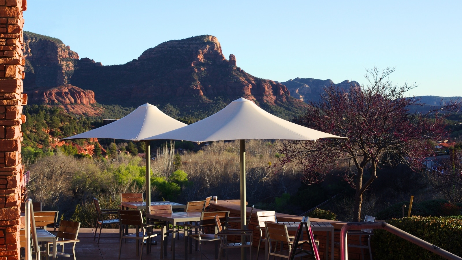 A photograph depicting a local cafe in downtown Sedona, Arizona, with mountain views in the background. The mountainous landscape provides a scenic backdrop, enhancing the ambiance of the cafe.