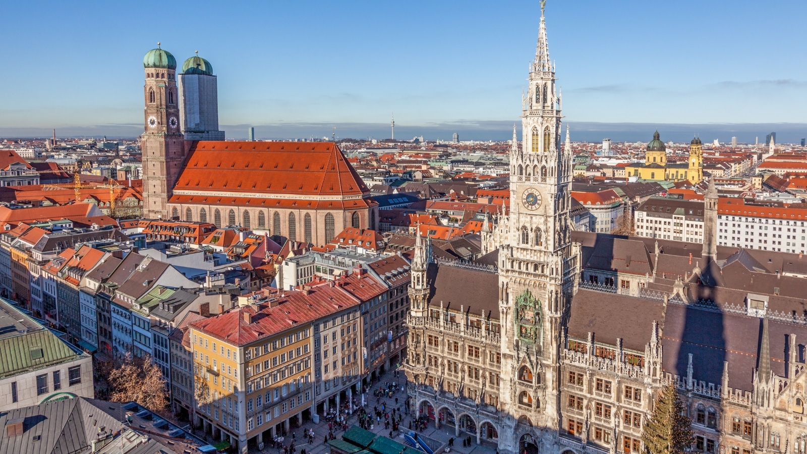 A cityscape view of Munich, Germany, featuring Marienplatz and the town hall. The image captures the urban environment with surrounding buildings and streets. Marienplatz, a central square, is dominated by the town hall's architecture.