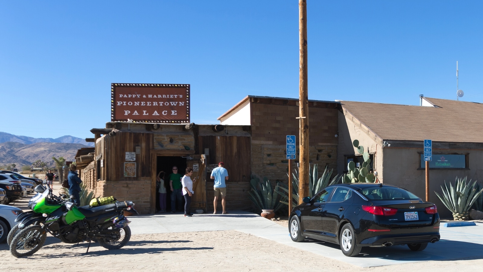 An exterior view of Pappy & Harriet's restaurant and music venue near Joshua Tree National Park in Pioneertown, California. The image showcases the architectural design of the establishment against a clear backdrop. Pappy & Harriet's features a modest yet distinctive appearance, consistent with the surrounding desert landscape.