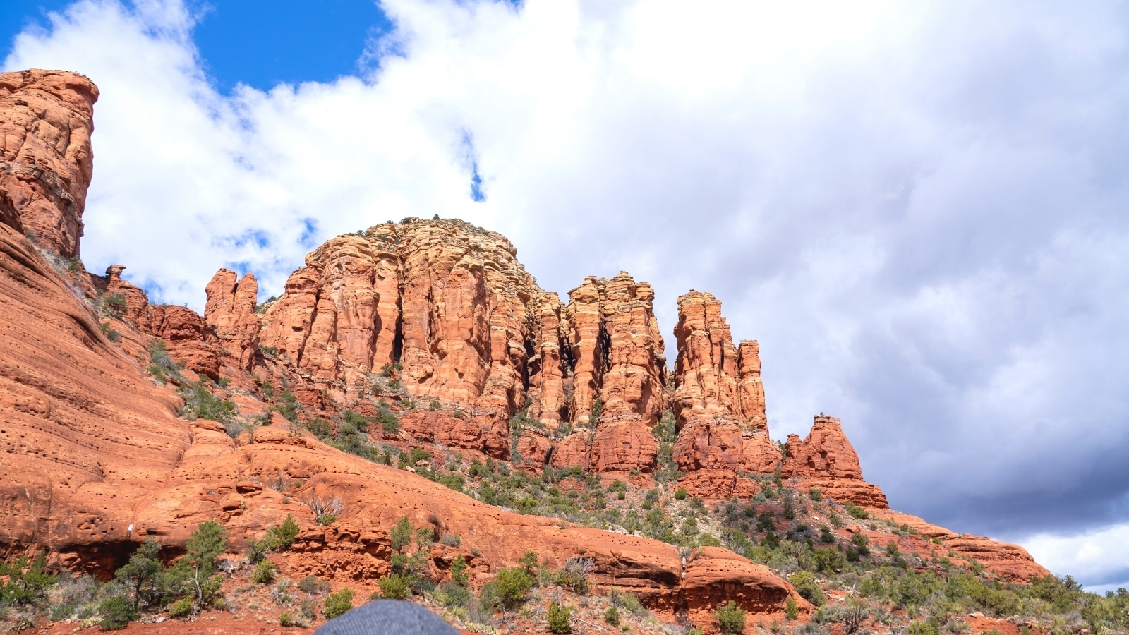 A photograph capturing a prominent rock formation in Sedona, Arizona. The image showcases the natural geological features of the area, with reddish-brown rock formations against a clear sky.
