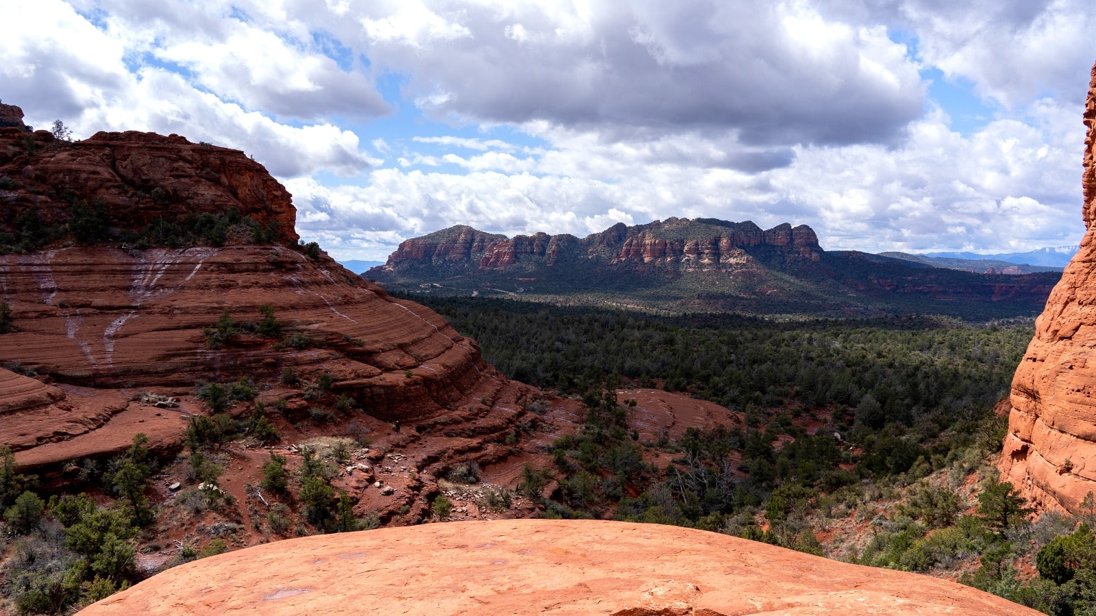 A photograph capturing a prominent rock formation in Sedona, Arizona. The image showcases the geological features of the rock formation, characterized by its rugged texture and distinct coloration.