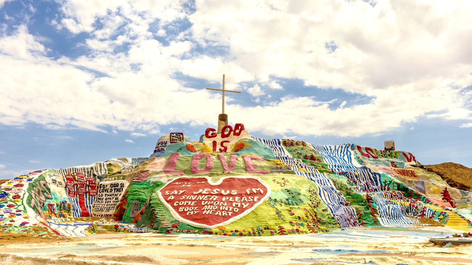 The image showcases the iconic tribute to God created by Leonard Knight. Salvation Mountain features a simple yet powerful message: 'God Is Love.'