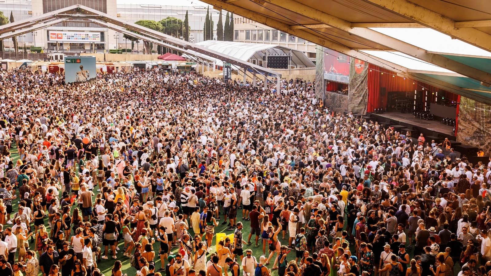 A visual capture of the crowd at Sonar Festival in Barcelona. The image displays a multitude of attendees gathered in an open area. Various individuals are observed, engaged in the festival atmosphere.
