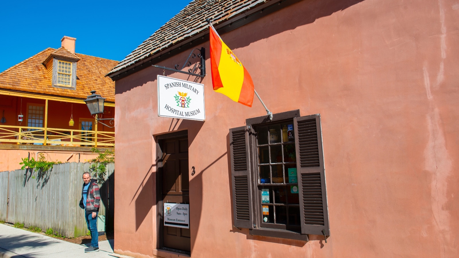 The image presents a close-up view of the Spanish Military Hospital Museum in St. Augustine, Florida. The building's exterior features a sign clearly indicating its name, "Spanish Military Hospital Museum,".