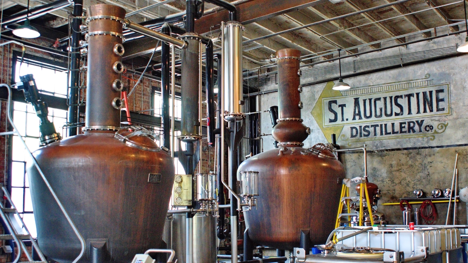 The image displays fermentation vats at a distillery located in Saint Augustine, Florida, USA.