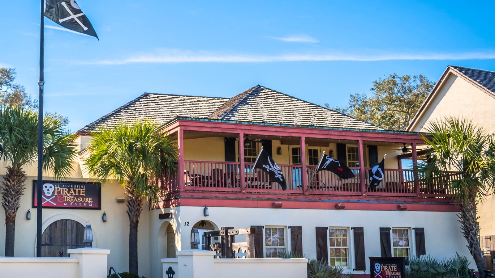 The image shows the exterior of the St. Augustine Pirate Museum, featuring its distinctive architecture and signage. The building appears well-maintained and inviting to visitors.