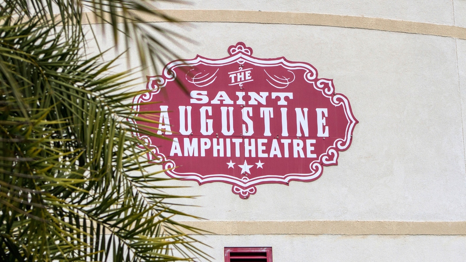 The image features a close-up view of a sign displaying "The St. Augustine Amphitheater."