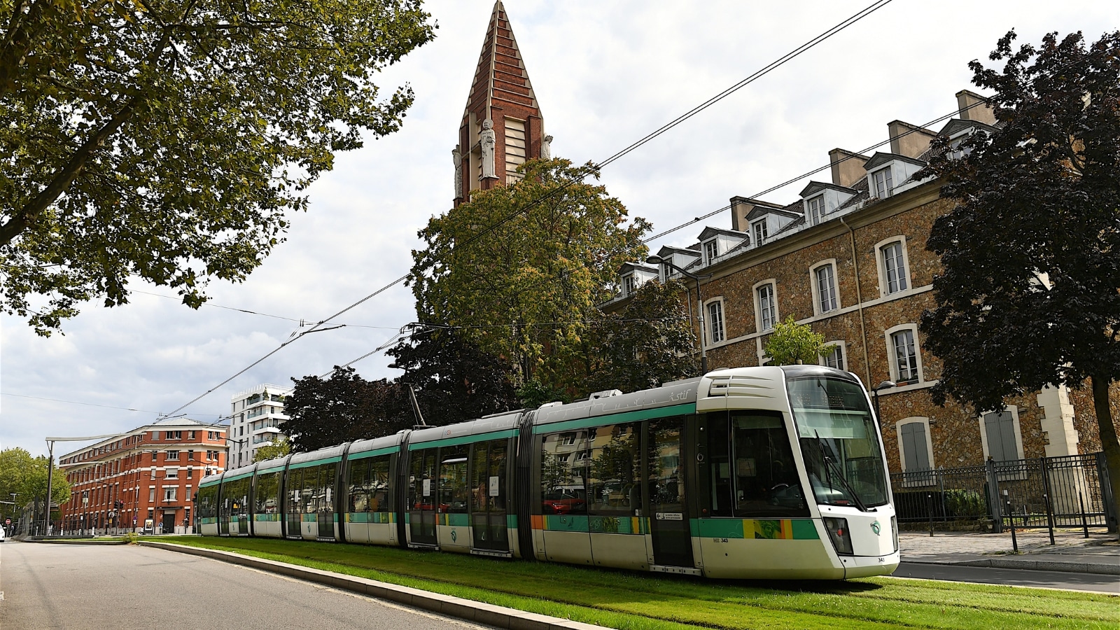 A photograph depicting a tramway in a Parisian street, France. The image captures the tramway's presence in an urban setting, revealing its typical street-level infrastructure. The surrounding environment includes a typical Parisian street with buildings.