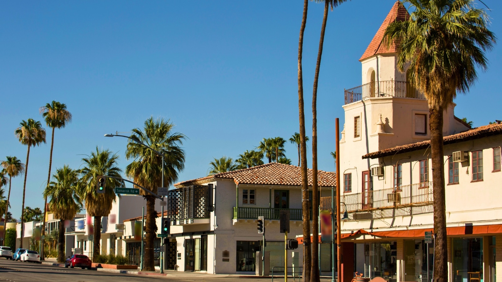 A photograph capturing downtown Palm Springs with a church in the foreground and a row of 2-story buildings along Palm Street. The image provides an overview of the cityscape, highlighting the architectural elements of the urban environment.