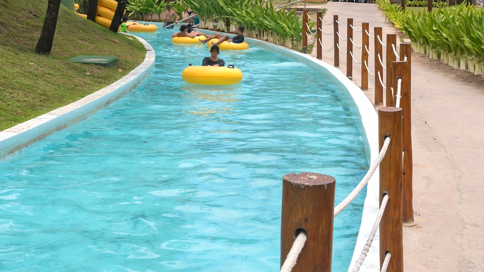 An image capturing a lazy river in Palm Springs, featuring individuals on yellow floating circles within the pool.