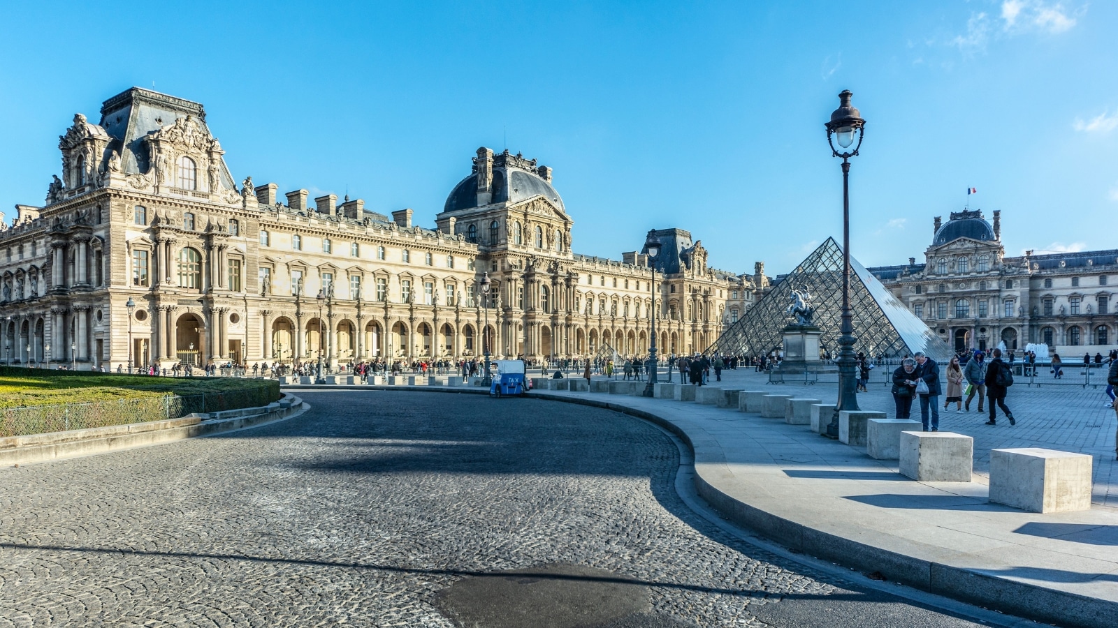 A photograph depicting the Louvre, Paris, France. The image captures the exterior of the renowned museum, showcasing its iconic architectural structure