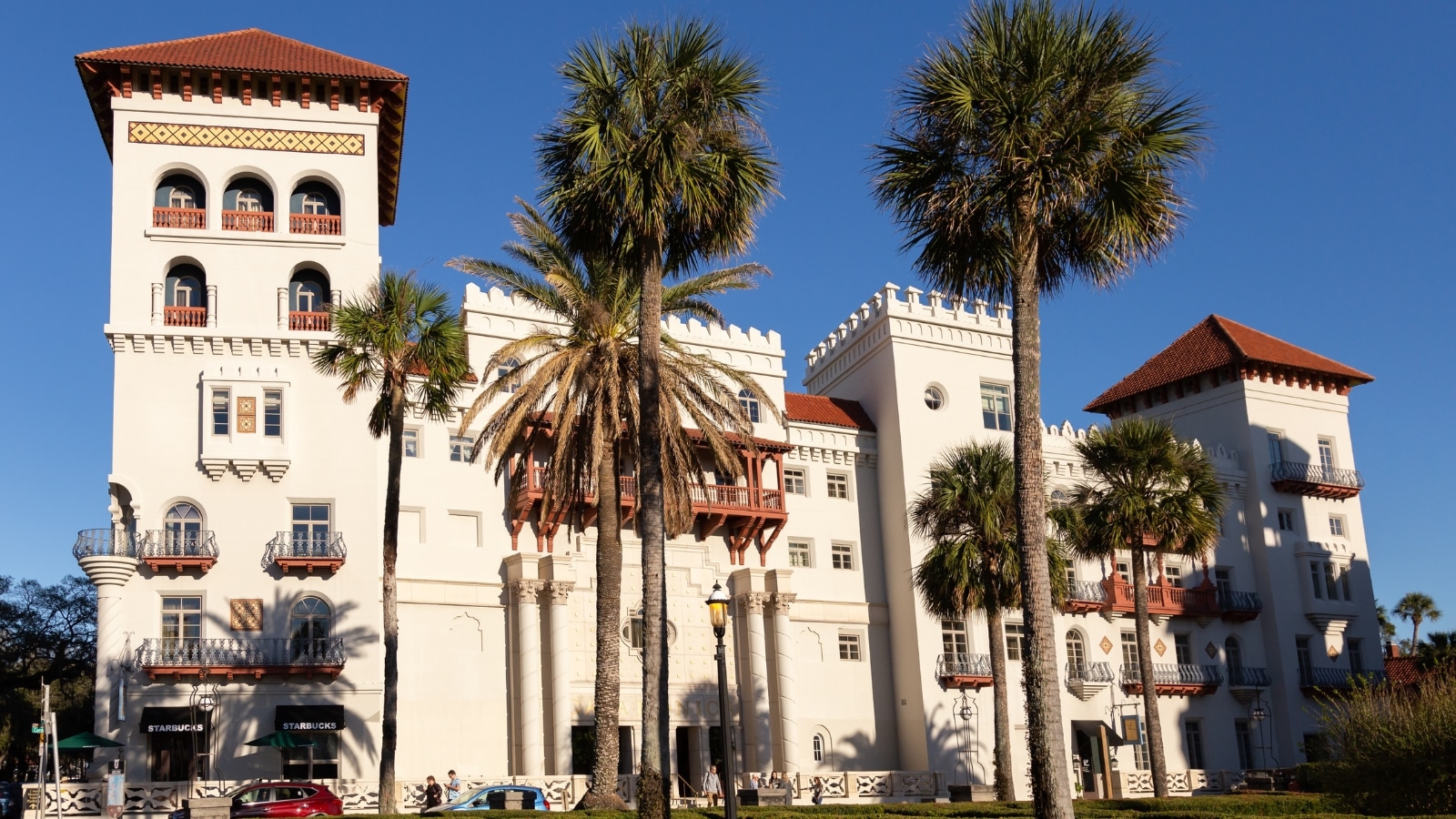 The image features the St. Augustine Casa Monica Resort and Spa, a Marriott Hotel, showcasing its architectural design and external features. The building appears grand and well-maintained, with a distinct style that reflects its luxury status.