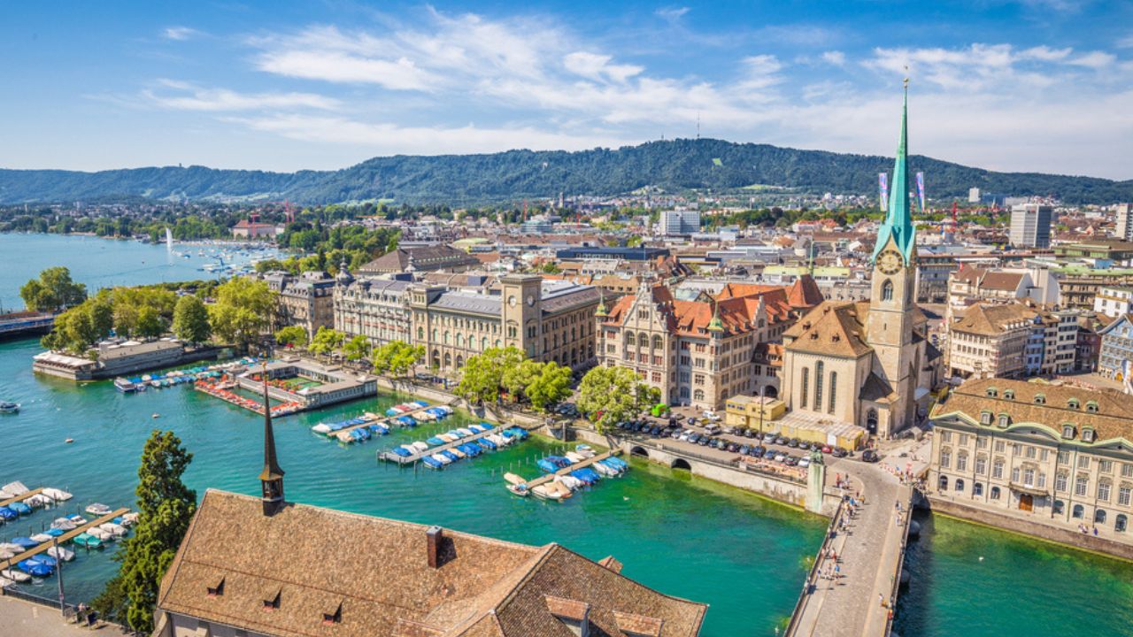 Aerial view of historic Zurich city center with famous Fraumunster Church and river Limmat at Lake Zurich from Grossmunster Church on a sunny day with clouds in summer, Canton of Zurich, Switzerland