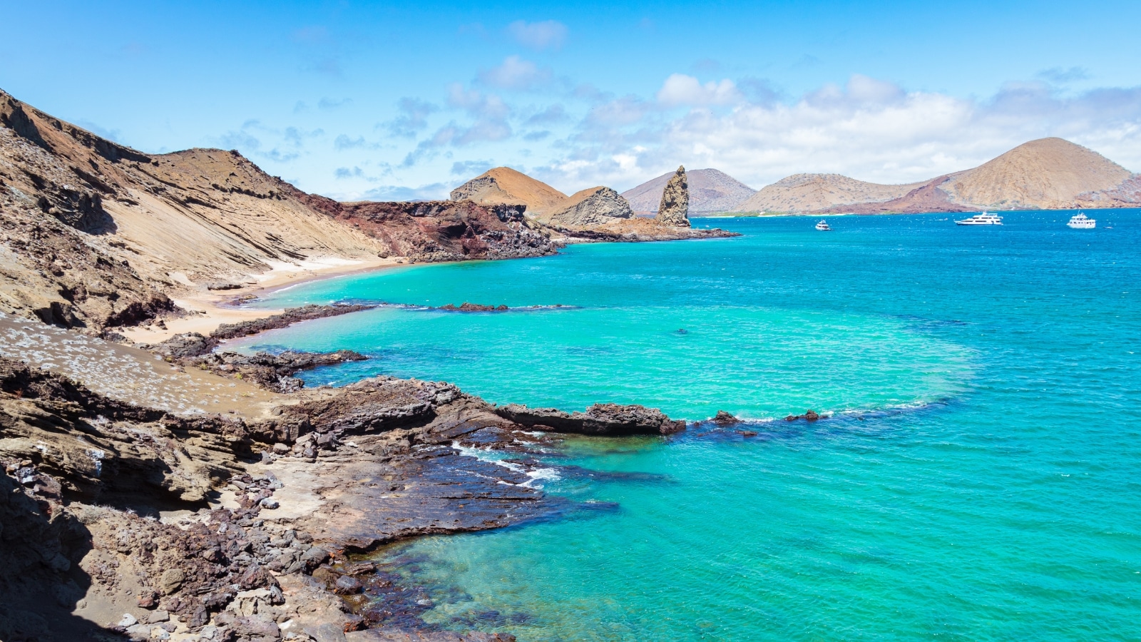 The image captures the famous Bartolomè Island in the Galapagos, Ecuador, showcasing its turquoise crystalline waters and the iconic rock pinnacle. The focus is on the natural beauty of the island's landscape, highlighting its clear waters and unique geological features.