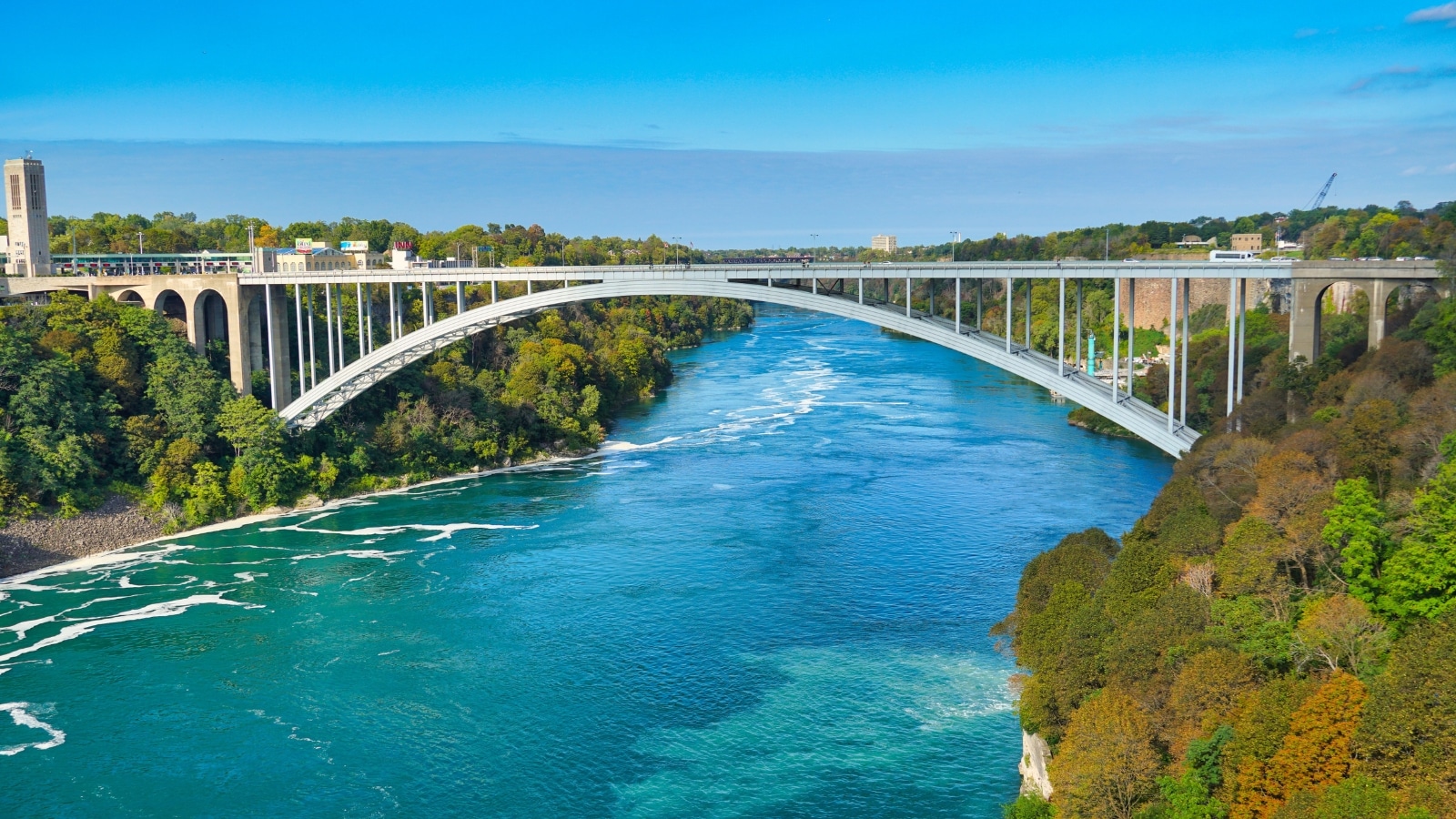 The image captures the famous Rainbow Bridge that connects the United States and Canada in New York, United States. The bridge's iconic arches and structural design are prominently displayed, emphasizing its significance as an international border crossing.