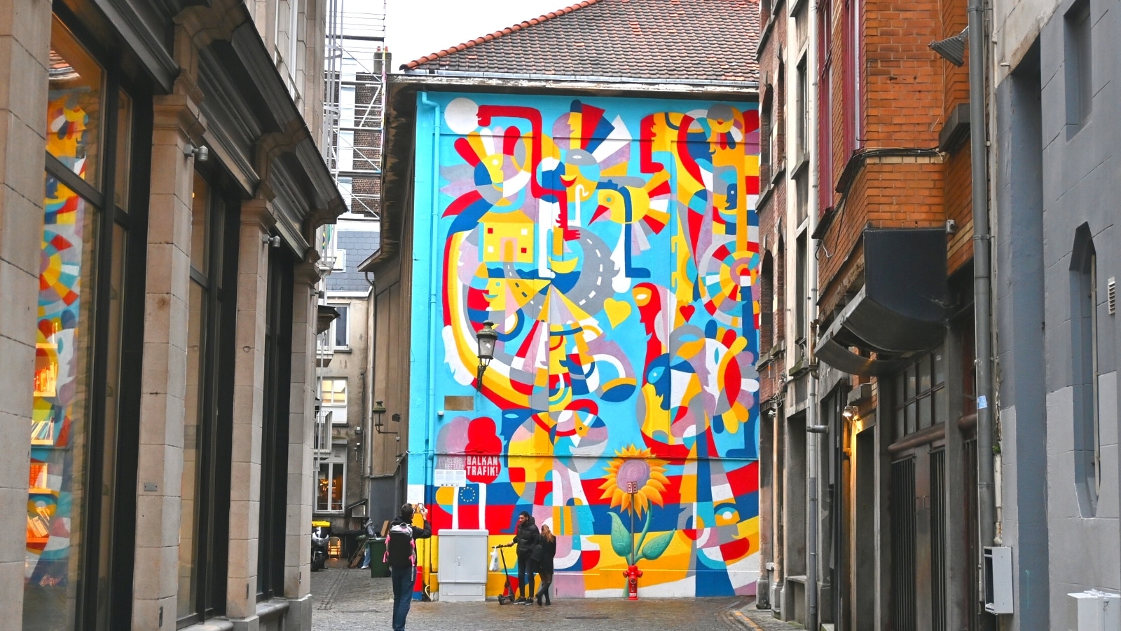 The image shows the mural "Samo se srcem jasno vidi" (It is Only With Heart One Can See Clearly) by Rikardo Druškić in Brussels, Belgium. The mural is a notable piece of street art, depicting a meaningful message.