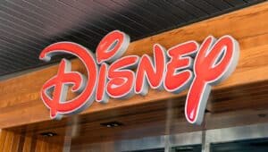 A closeup image captures a prominent red sign bearing the word "Disney" in bold, classic font. The sign appears large and easily recognizable.