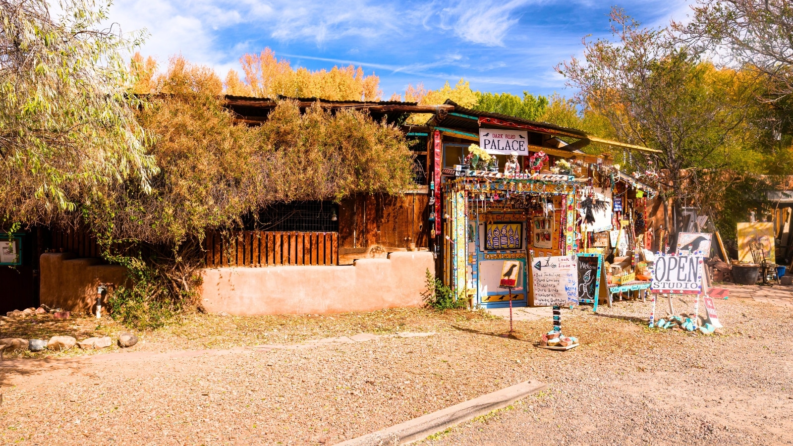 Santa Fe, New Mexico's Popular Canyon Road in the downtown district is a vibrant strip lined with numerous art galleries. The scene in the foreground captures a small kiosk adorned with colorful paintings, adding to the artistic atmosphere of the area.