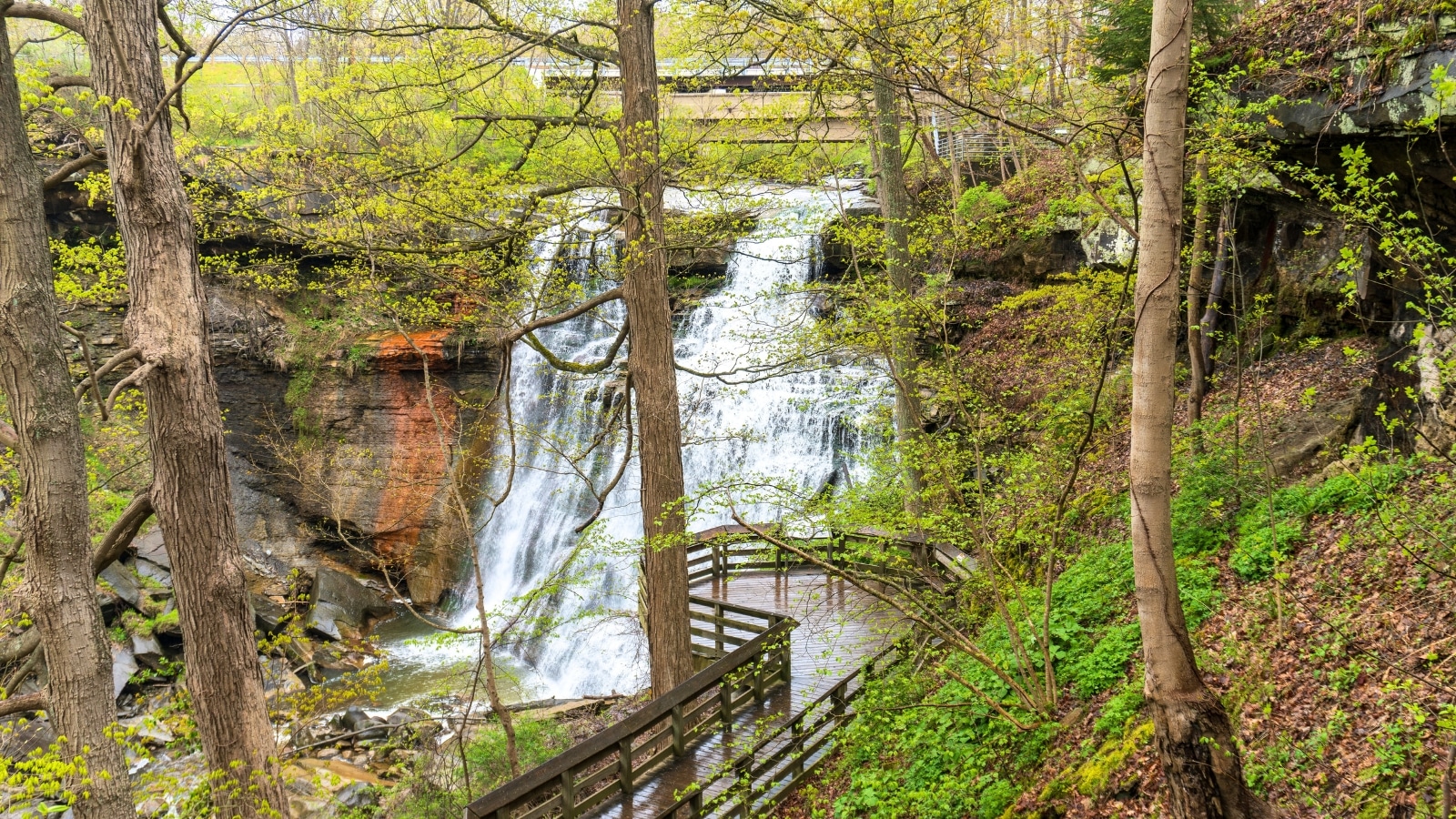Brandywine Falls, located along Brandywine Creek, a tributary of the Cuyahoga River, within Cuyahoga Valley National Park in Sagamore Hills Township, Ohio. A wooden viewing platform is visible in the foreground, providing a vantage point for observing the waterfall.
