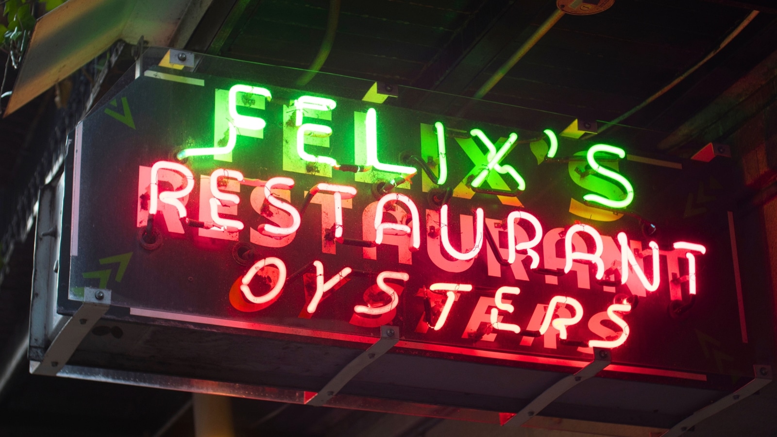 In New Orleans, LA, a neon sign reads "Felix's Restaurant Oysters." "Felix's" is displayed in green, while "Restaurant Oysters" is in red.