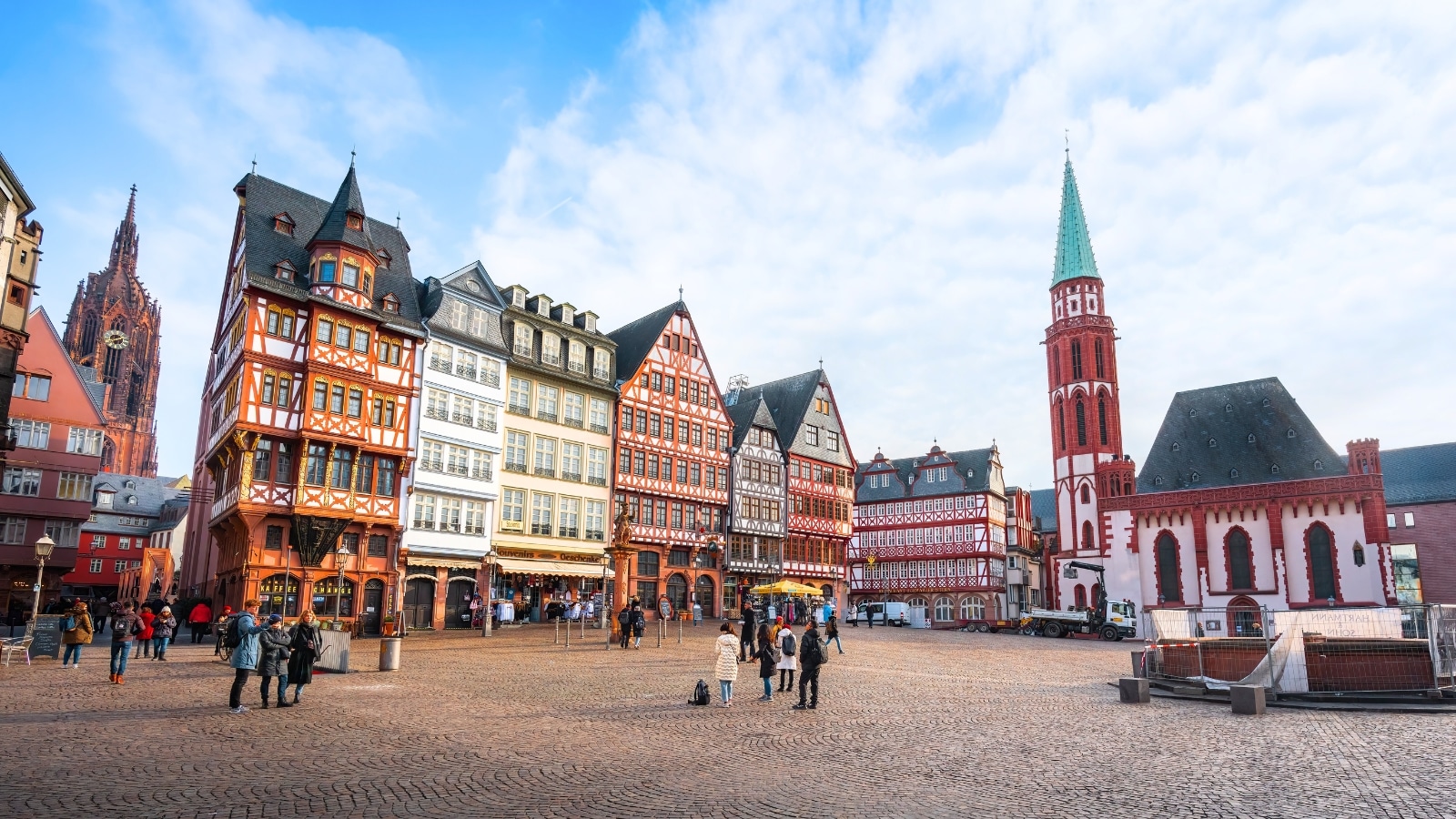 In Frankfurt, Germany, Romerberg Square showcases the Old St. Nicholas Church and colorful half-timbered buildings. The church boasts a historic architectural style with intricate details. Surrounding it are traditional half-timbered buildings painted in a variety of vibrant colors.