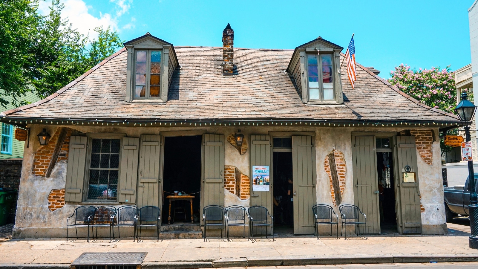 Lafitte's Blacksmith Shop Bar in the French Quarter of New Orleans, Louisiana, is a historic building with weathered brick walls and wooden shutters.