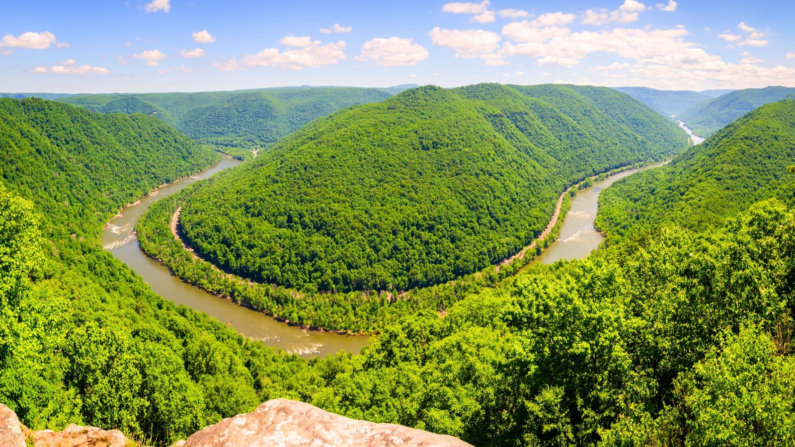 An overlook at New River Gorge National Park and Preserve in southern West Virginia reveals the winding New River amid the Appalachian Mountains. The river snakes through the lush, forested landscape, flanked by steep.