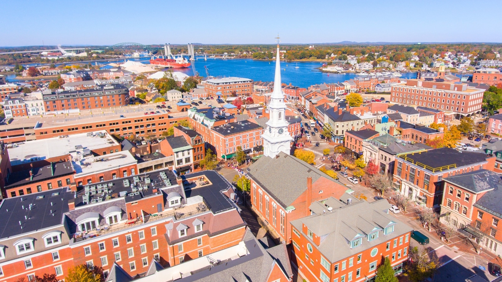 Portsmouth's historic downtown in New Hampshire, USA, is captured in an aerial view at Market Square. The scene features a cluster of historic buildings, with the iconic North Church standing prominently on Congress Street.
