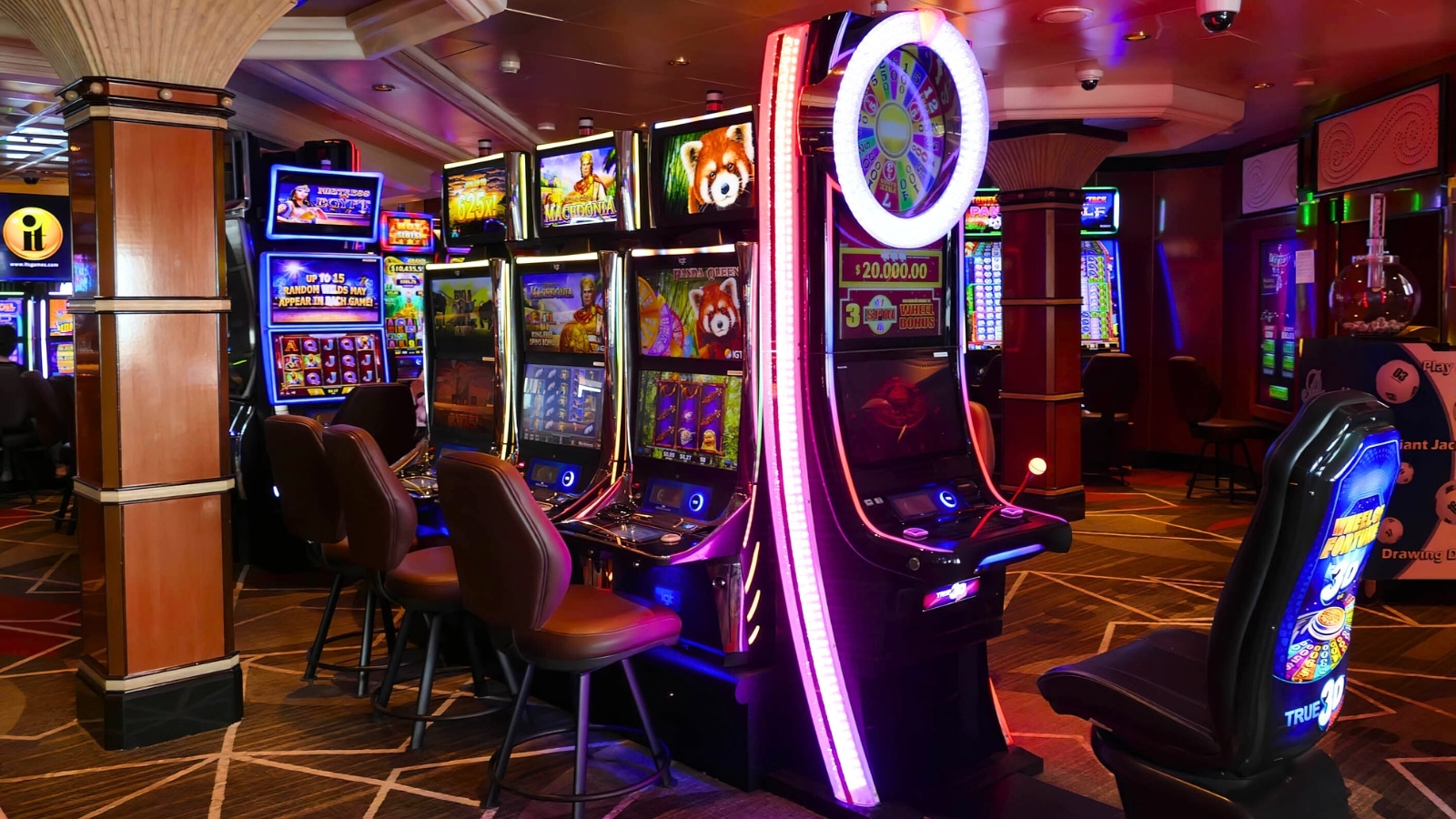 Slot machines in casinos feature a dimly lit ambiance, accentuating the bright colors of the various slot machines offering different games.
