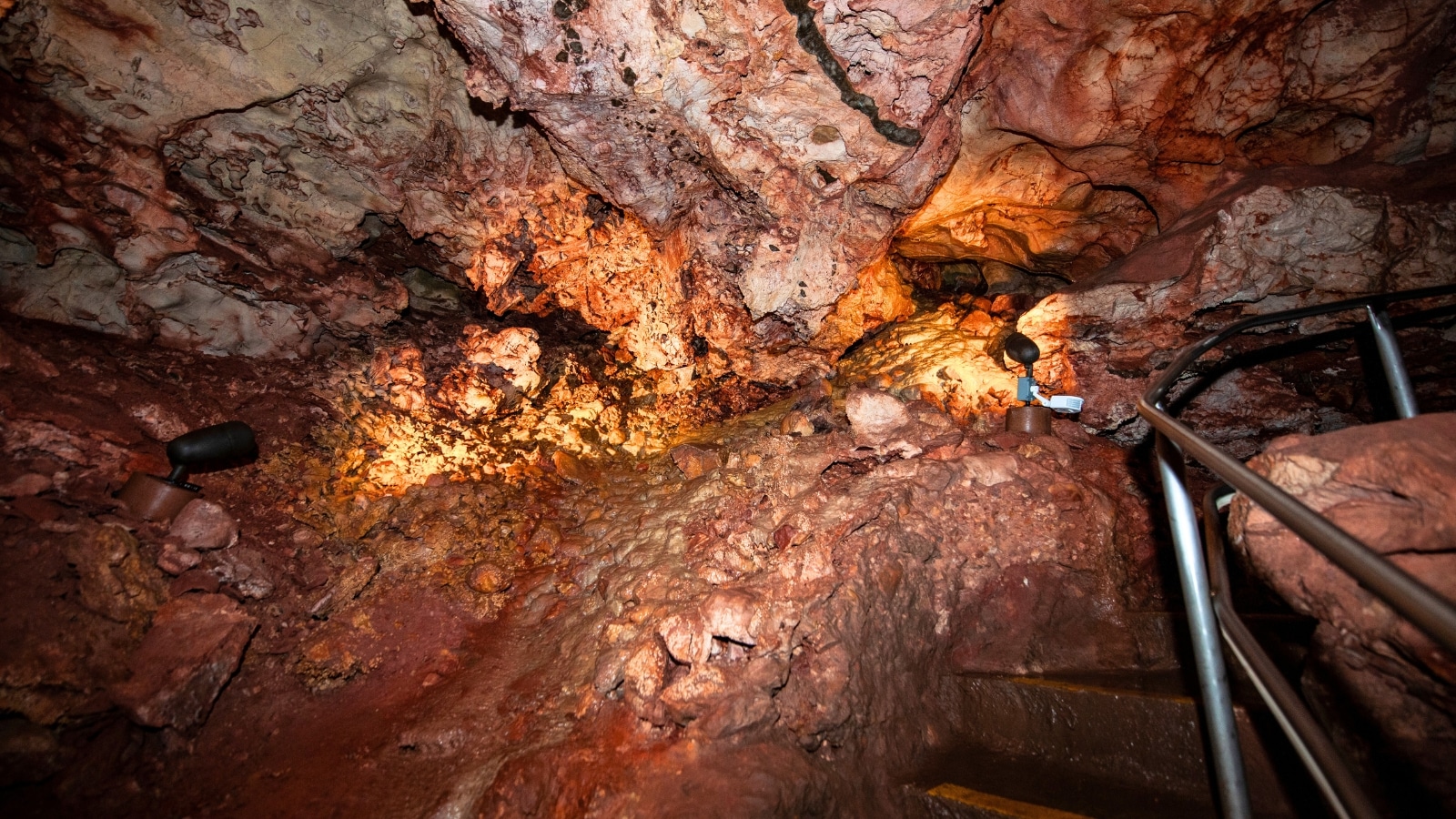 Wind Cave National Park in South Dakota features a complex cave system with intricate passageways and unique formations. The cave consists of boxwork and frostwork formations, displaying shades of brown, beige, and white.