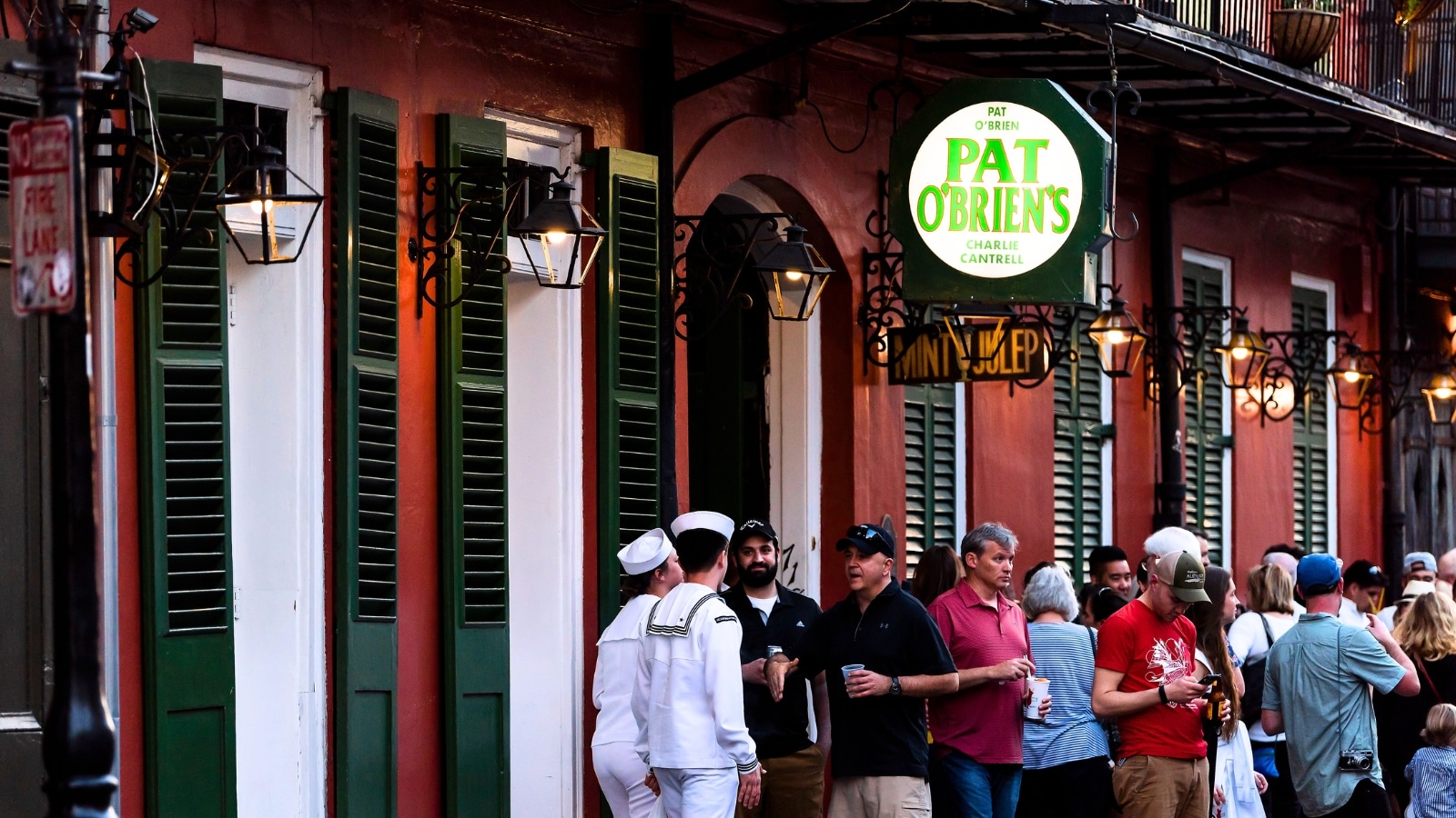 New Orleans, USA, features the historic Old Town, with St. Peter Pierre Street bustling with activity. Many people stand in line at the famous Pat O'Brien's bar.