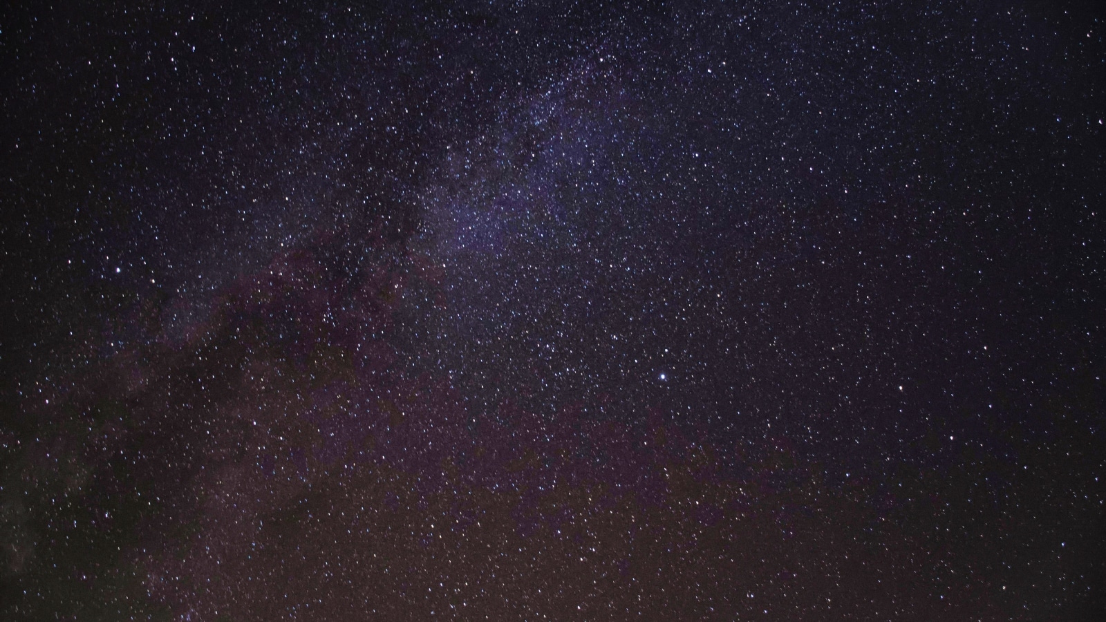 An astrophotography shot captures the starry night sky over South Lake Tahoe, California. The scene is dominated by a vast expanse of stars against a dark backdrop.