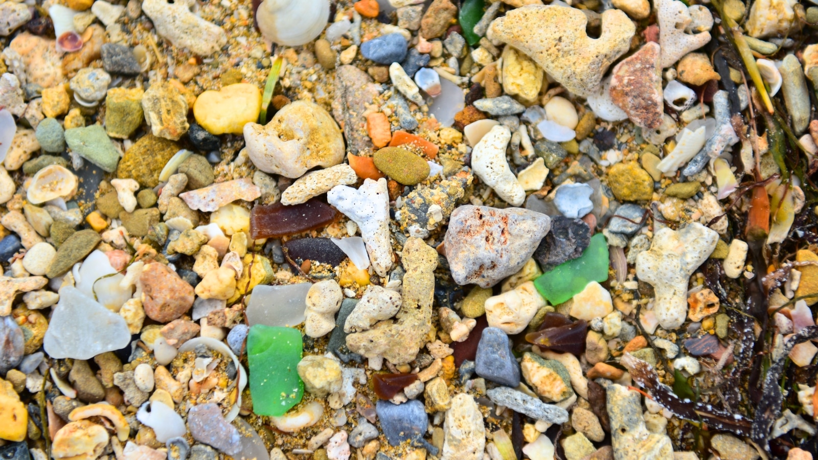 Sea Glass Beach in Okinawa, Japan, is renowned for its colorful glass bits scattered throughout the sand. The beach has a unique appearance due to the abundance of sea glass, which comes in various sizes and colors.