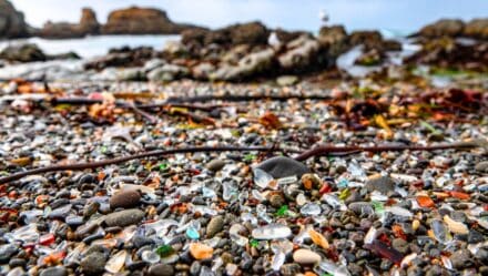 Glass Beach in Fort Bragg, California features a close-up view of multicolored pebbles. The beach consists of smooth, rounded pieces of glass in various colors such as blue, green, red, and white.